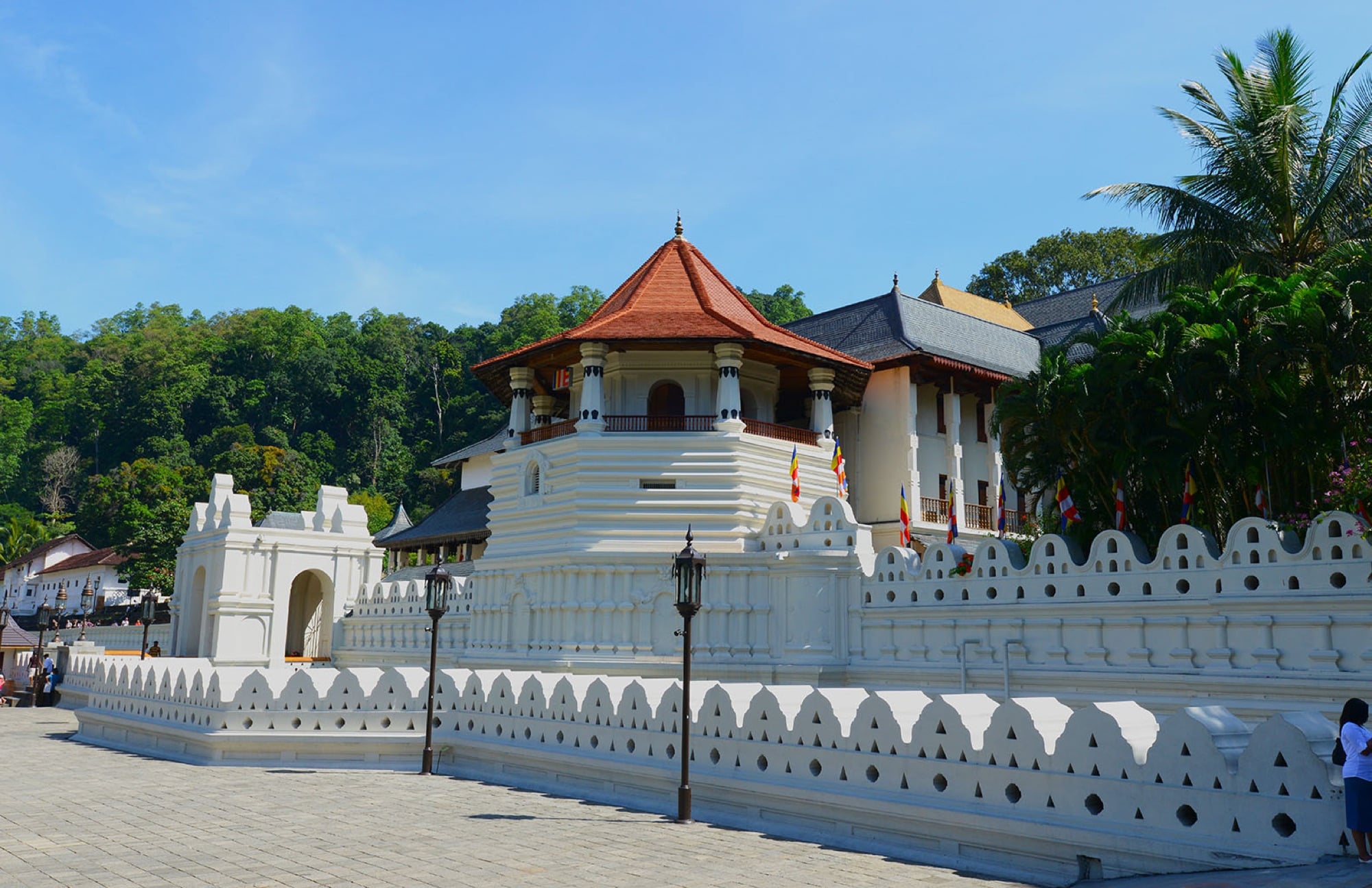 The white Temple of the Sacred Tooth Relic in Kandy under a clear blue sky